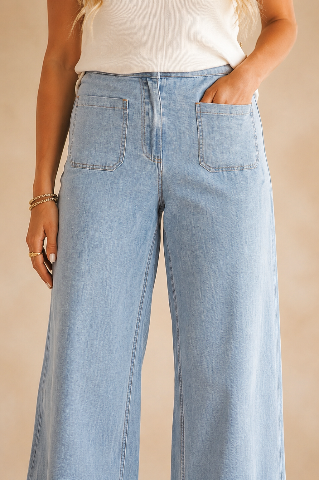 Close view of the Blue Haven jeans showing the Beau Blue wash, high-rise waist, oversized front patch pockets and vertical leg seams.
