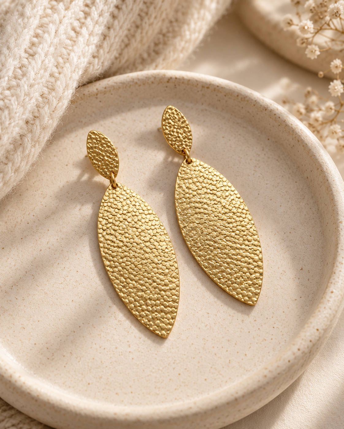 Golden Hour statement earrings styled in a neutral ceramic jewelry dish with soft cream details