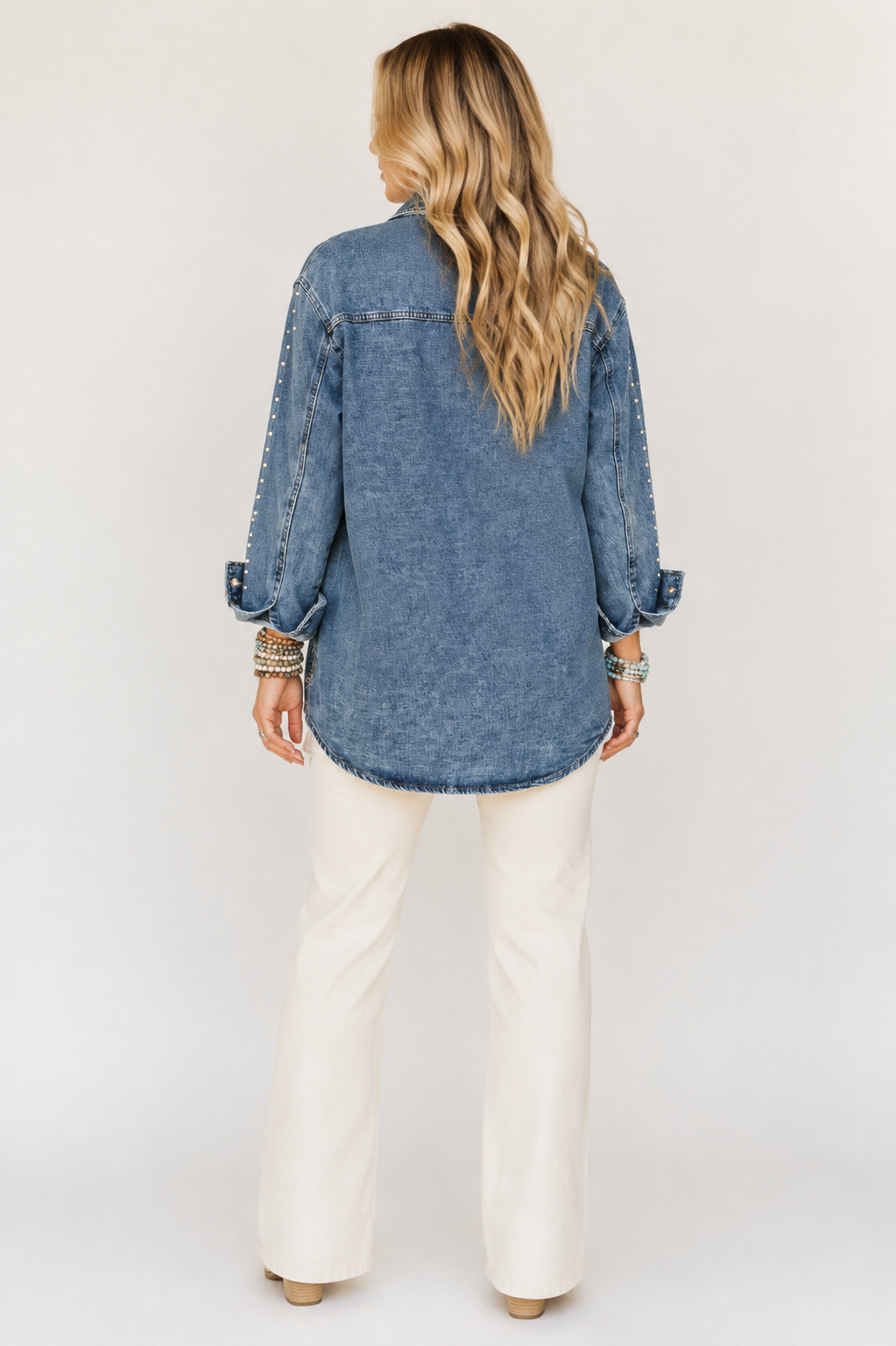 Back view of the Silver Spur longline denim jacket showing its relaxed fit, rounded hem and studded sleeves.