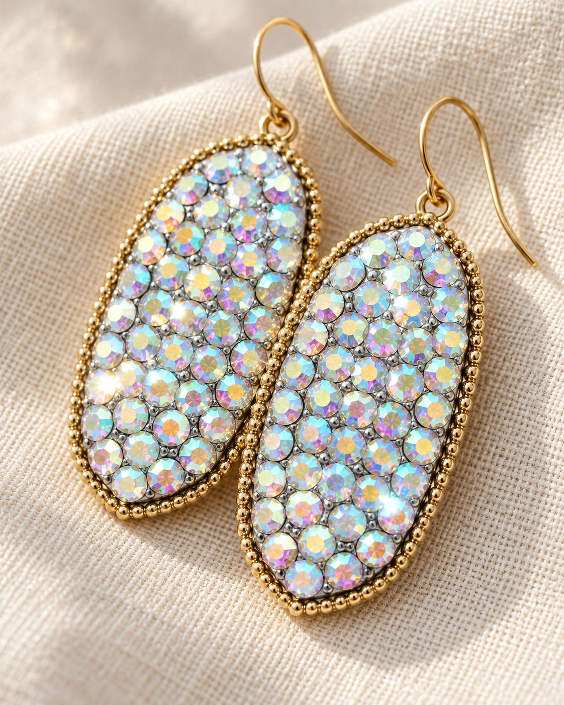 Close-up of Moonlight Spark earrings showing rainbow-reflective crystal-style details and gold-tone edging