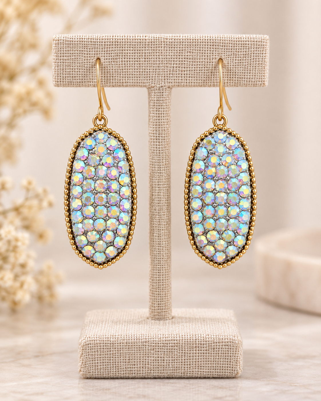 Moonlight Spark earrings displayed on a neutral linen jewelry stand with multicolor reflective sparkle