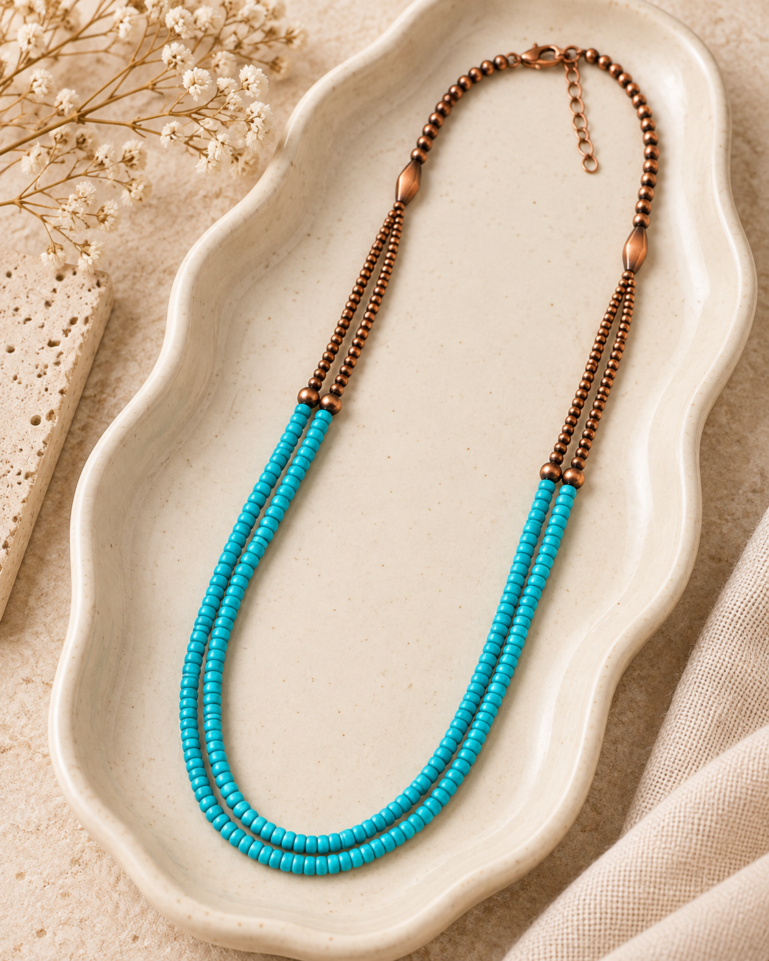 Close-up of turquoise-colored seed-style beads and copper-tone bead accents on double-strand necklace
