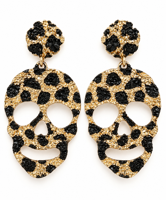 A pair of gold and black leopard-print skull drop earrings on a plain white background.