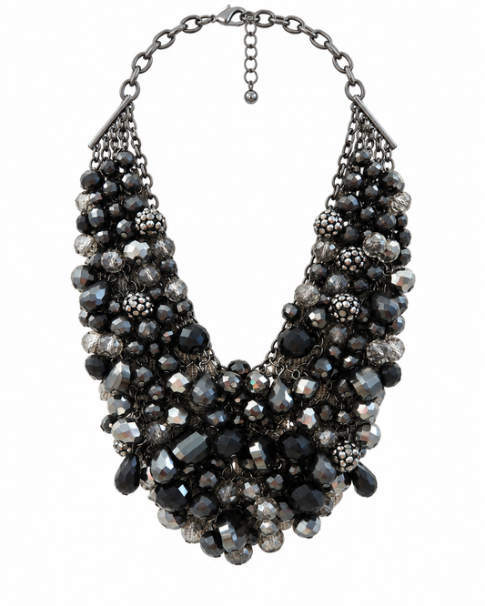 A multi-strand statement bib necklace featuring faceted black, dark gray, and clear crystal beads set in dark silver-tone metal, shown against a plain white background.