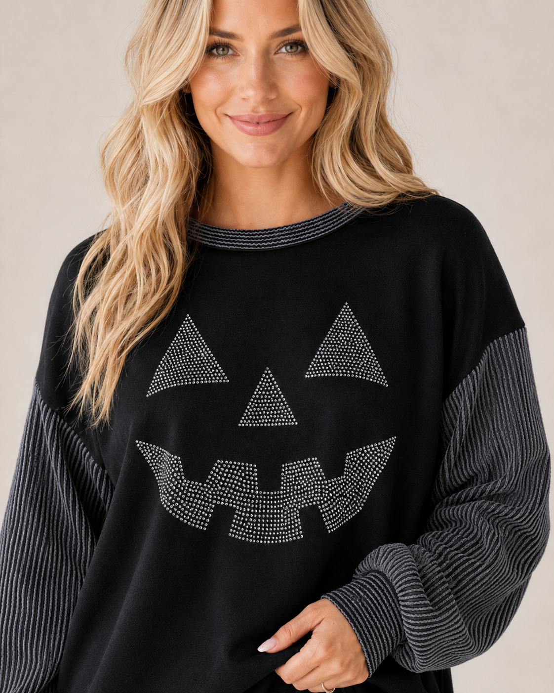 Close-up of the Midnight Jack Rhinestone Top showing the silver pumpkin face, striped neckline, and textured contrast sleeves.