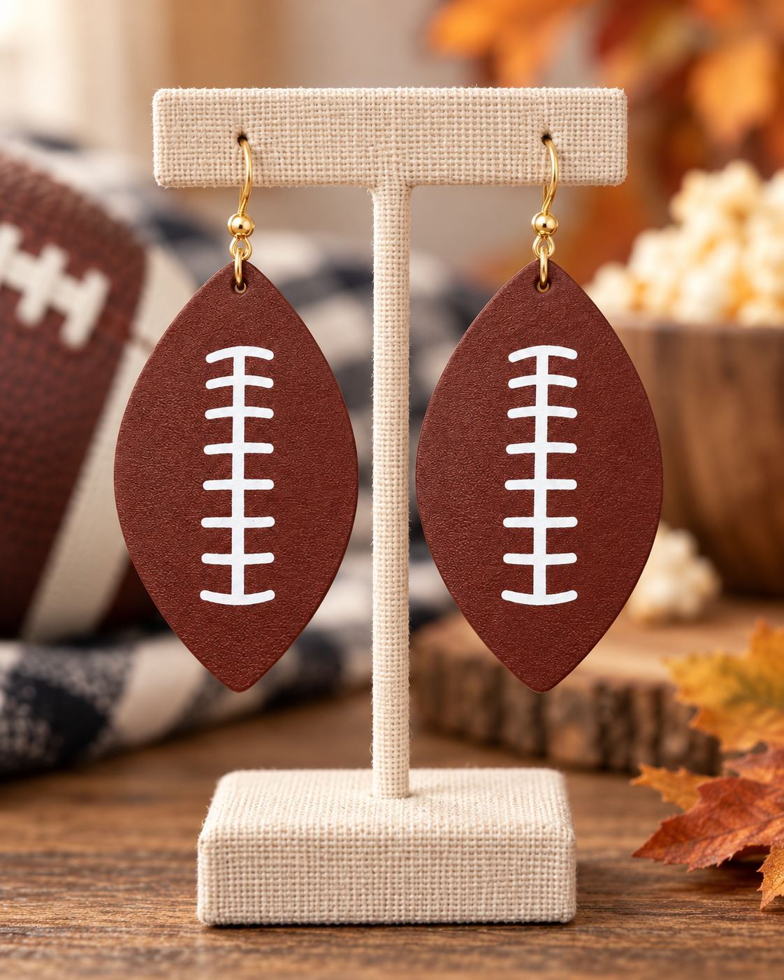 Lifestyle image of woman wearing football drop earrings with a denim jacket and neutral game-day outfit