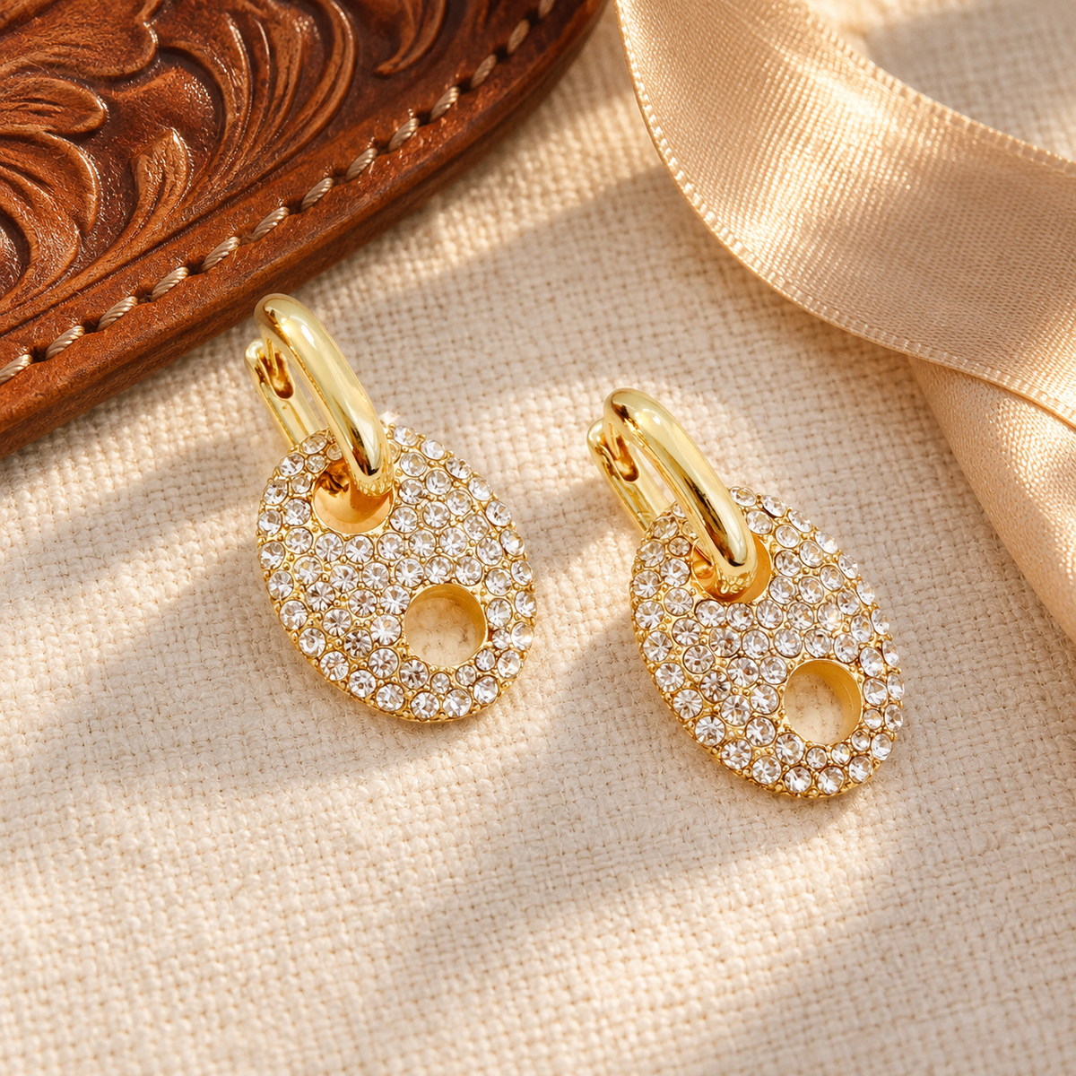 Gold pavé horse bit earrings styled with leather and satin