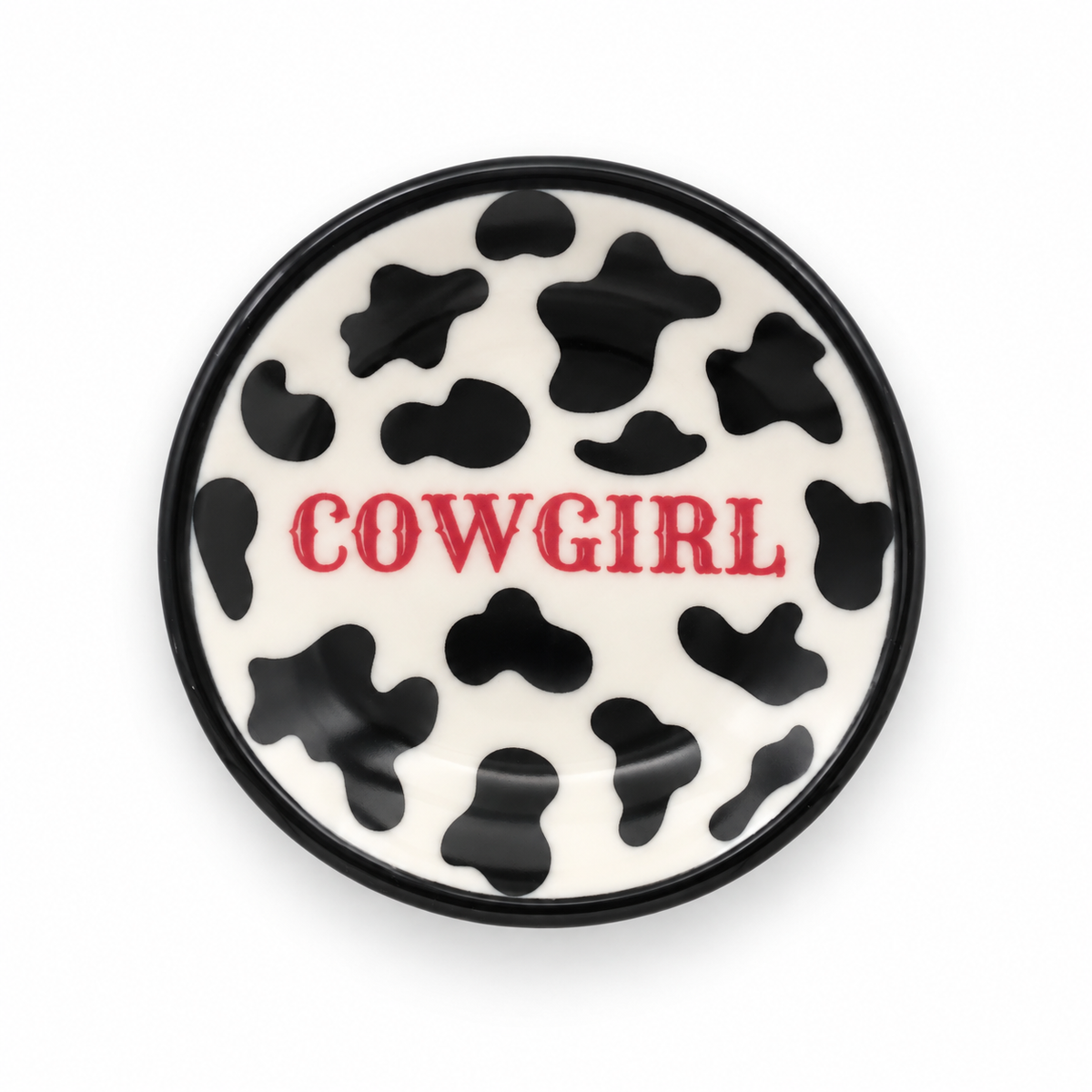 Cowprint Cowgirl ceramic ring dish with black cow spots, black rim and pink lettering on white background
