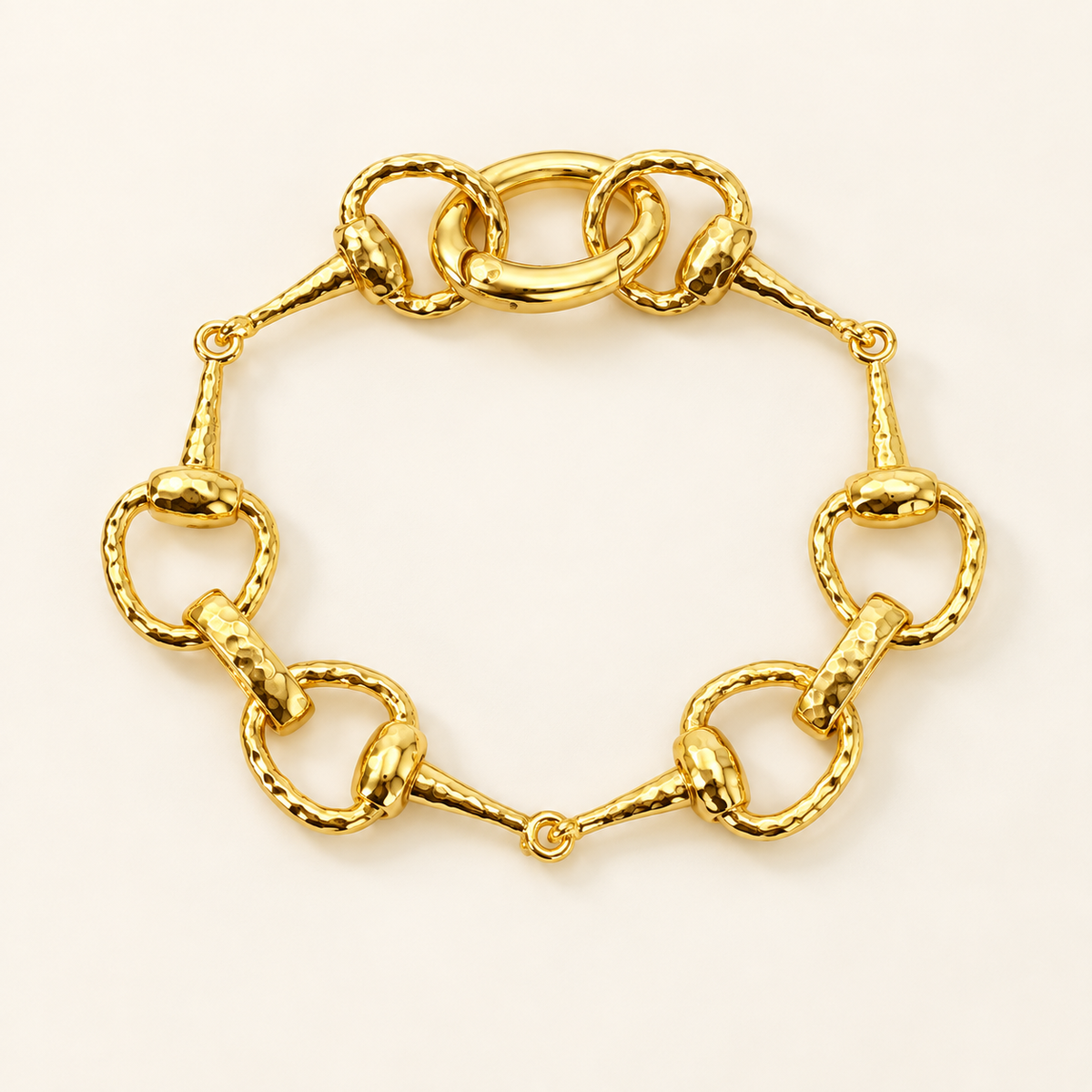 Golden equestrian horse bit link bracelet on soft ivory background