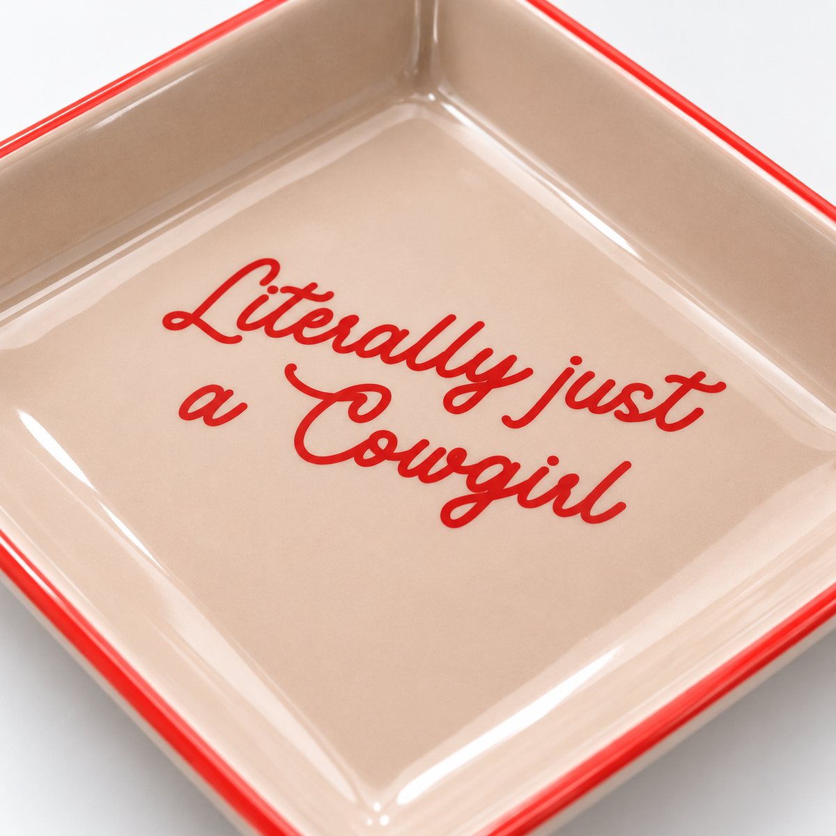 Close-up of Literally Just A Cowgirl trinket tray showing glossy ceramic finish and red script lettering