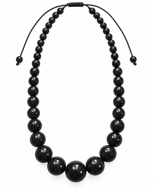 Midnight Muse graduated black bead necklace with glossy oversized beads and adjustable black cord on a white background