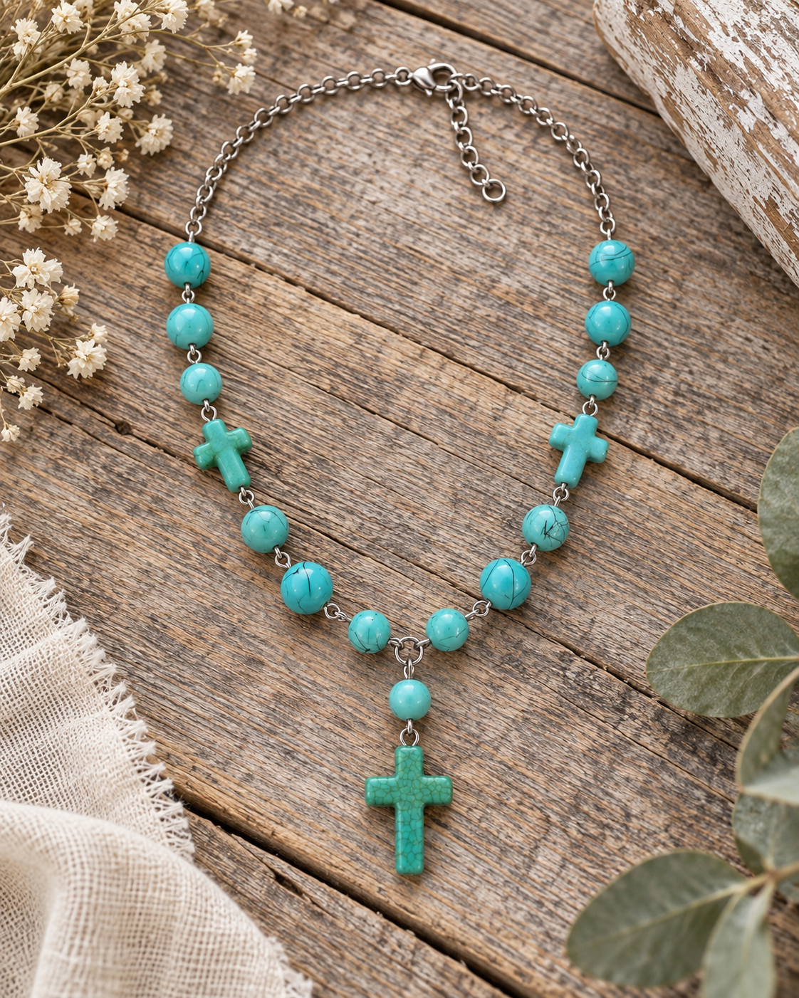 Desert Faith cross necklace styled on rustic wood with turquoise-colored beads and silver-tone chain