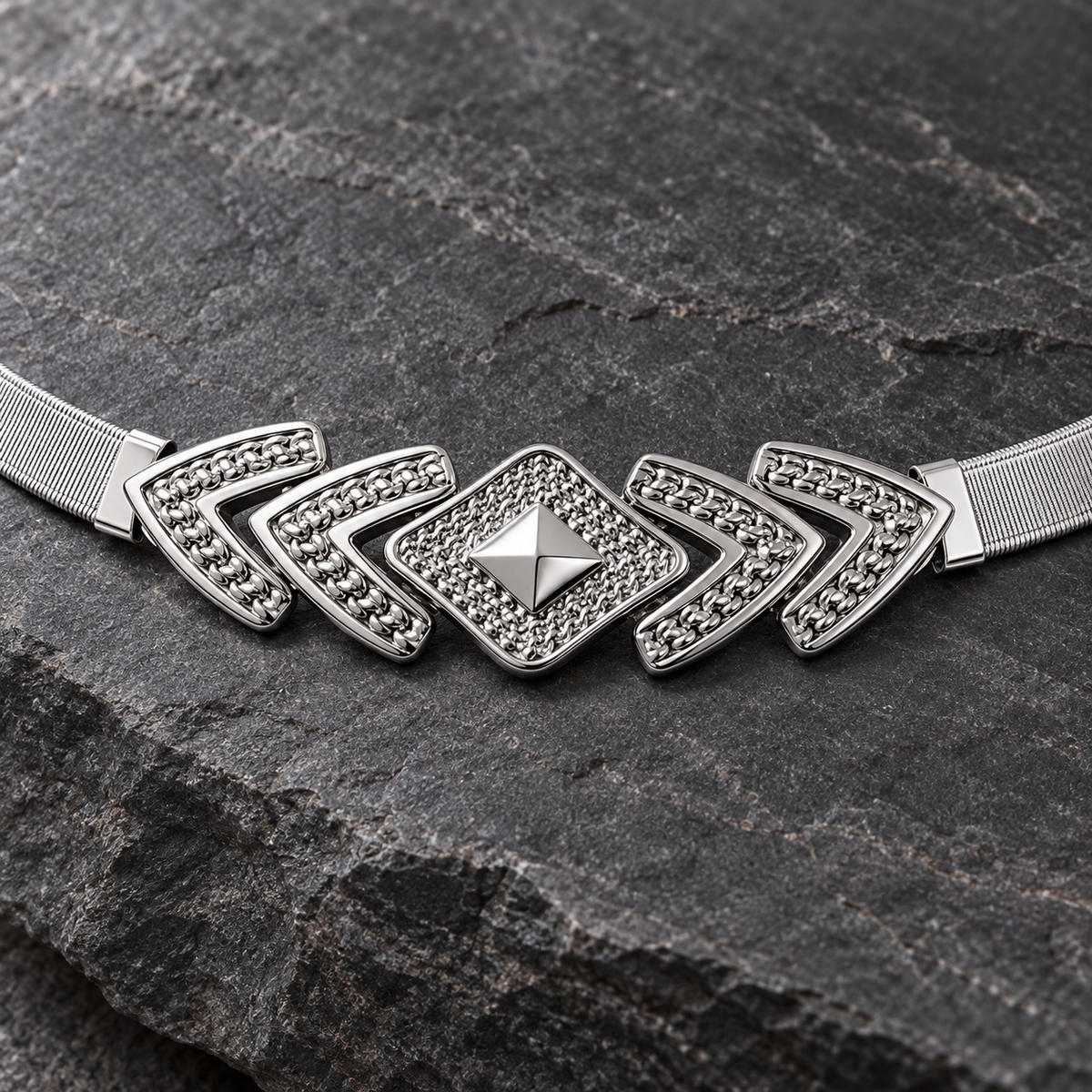 Close-up of the silver-tone geometric belt centerpiece on charcoal stone.