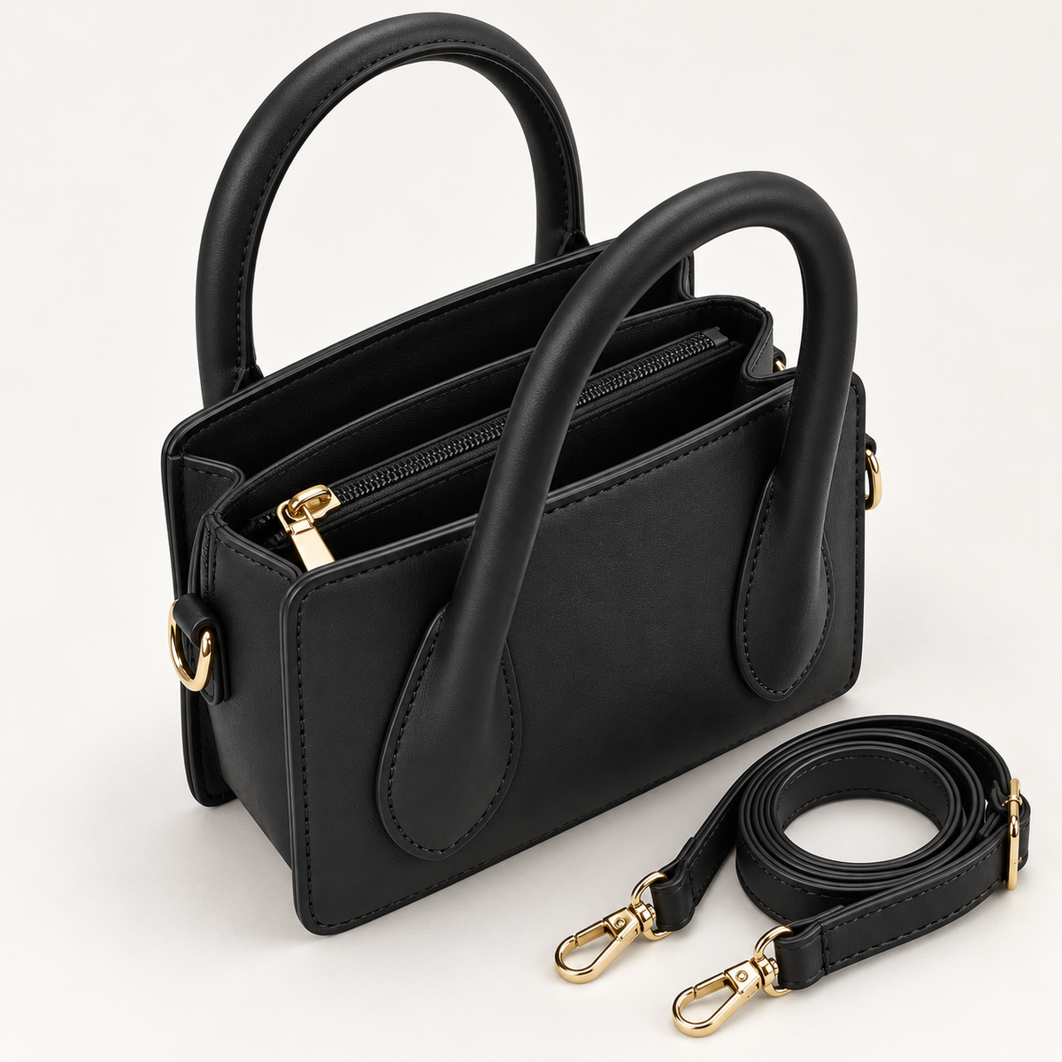 Open black Park Avenue mini satchel showing divided interior compartments and detachable shoulder strap