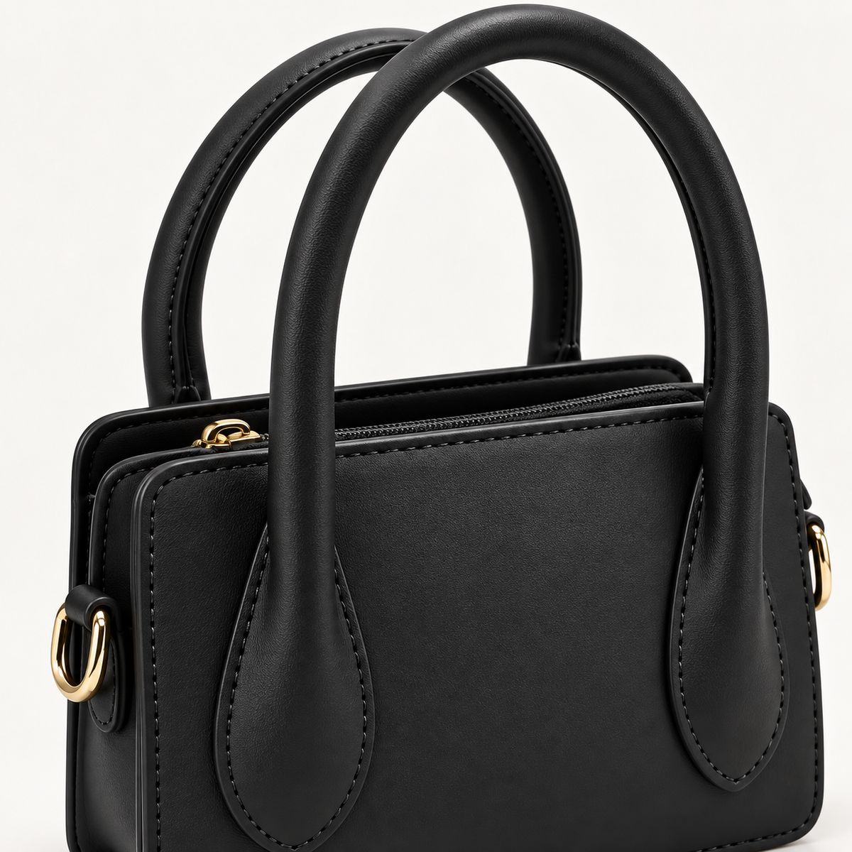 Close-up of black Park Avenue mini satchel showing smooth finish, stitching, handles and gold-tone hardware