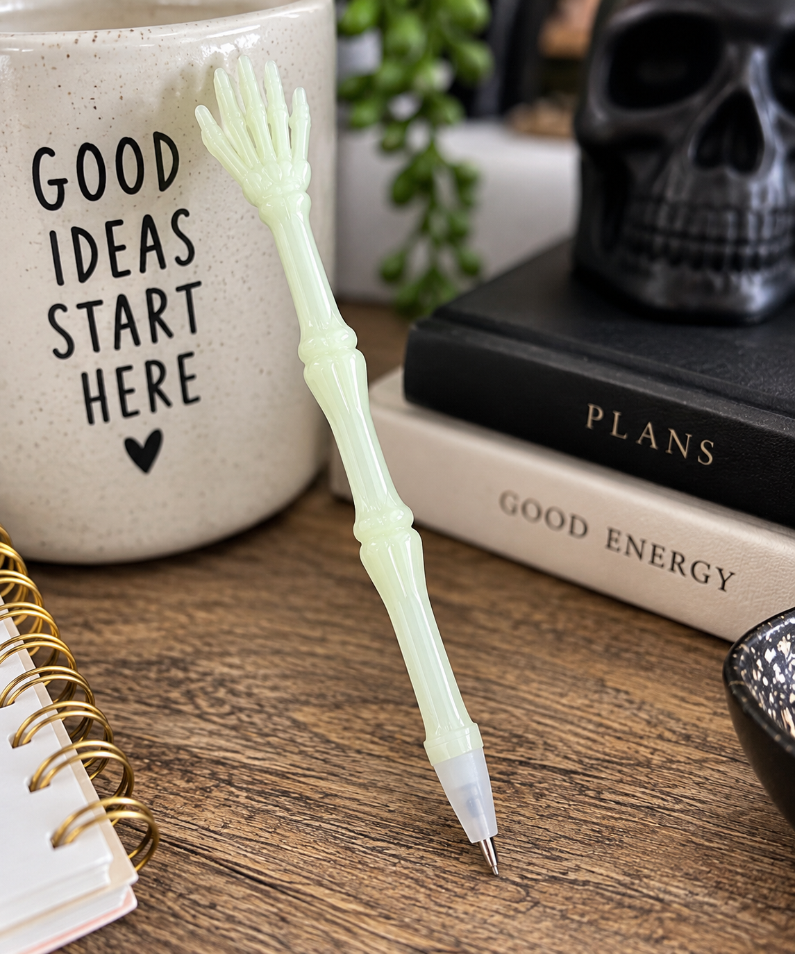 Skeleton hand novelty pen displayed upright with black pumpkin and Halloween desk accessories