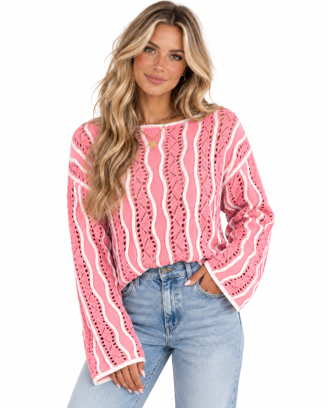 A woman wearing a pink and white patterned knit long-sleeve top with blue jeans, photographed against a plain white background.