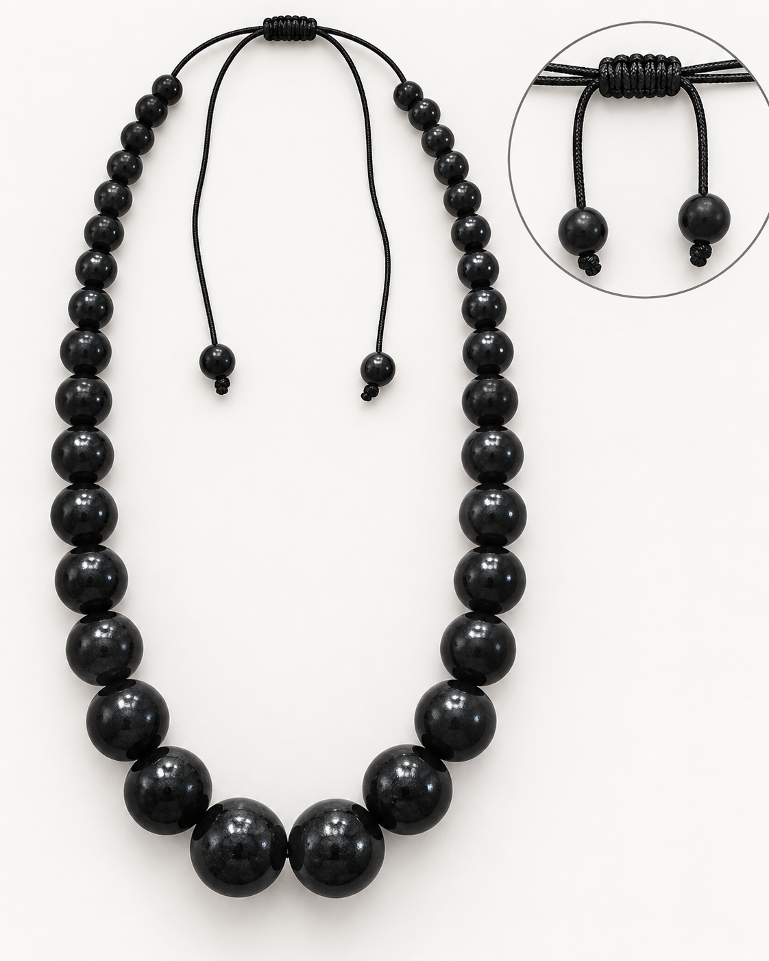 Attribute image showing adjustable black cord closure and bead-ended ties on graduated black necklace