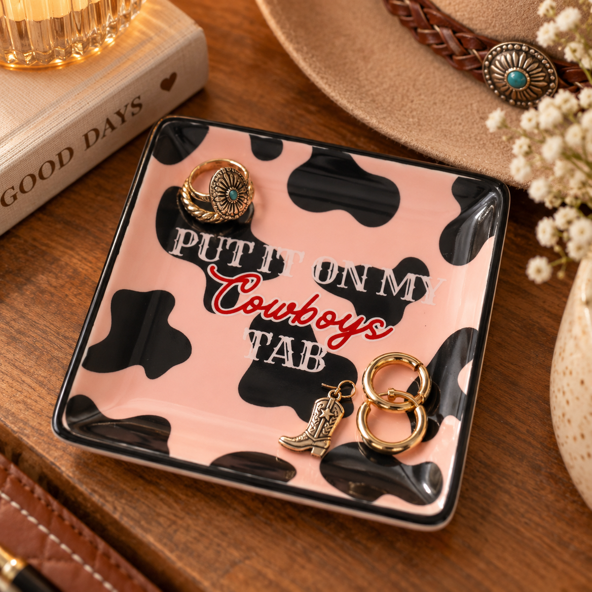 Pink cowprint square jewelry tray with western accessories and gold hoops
