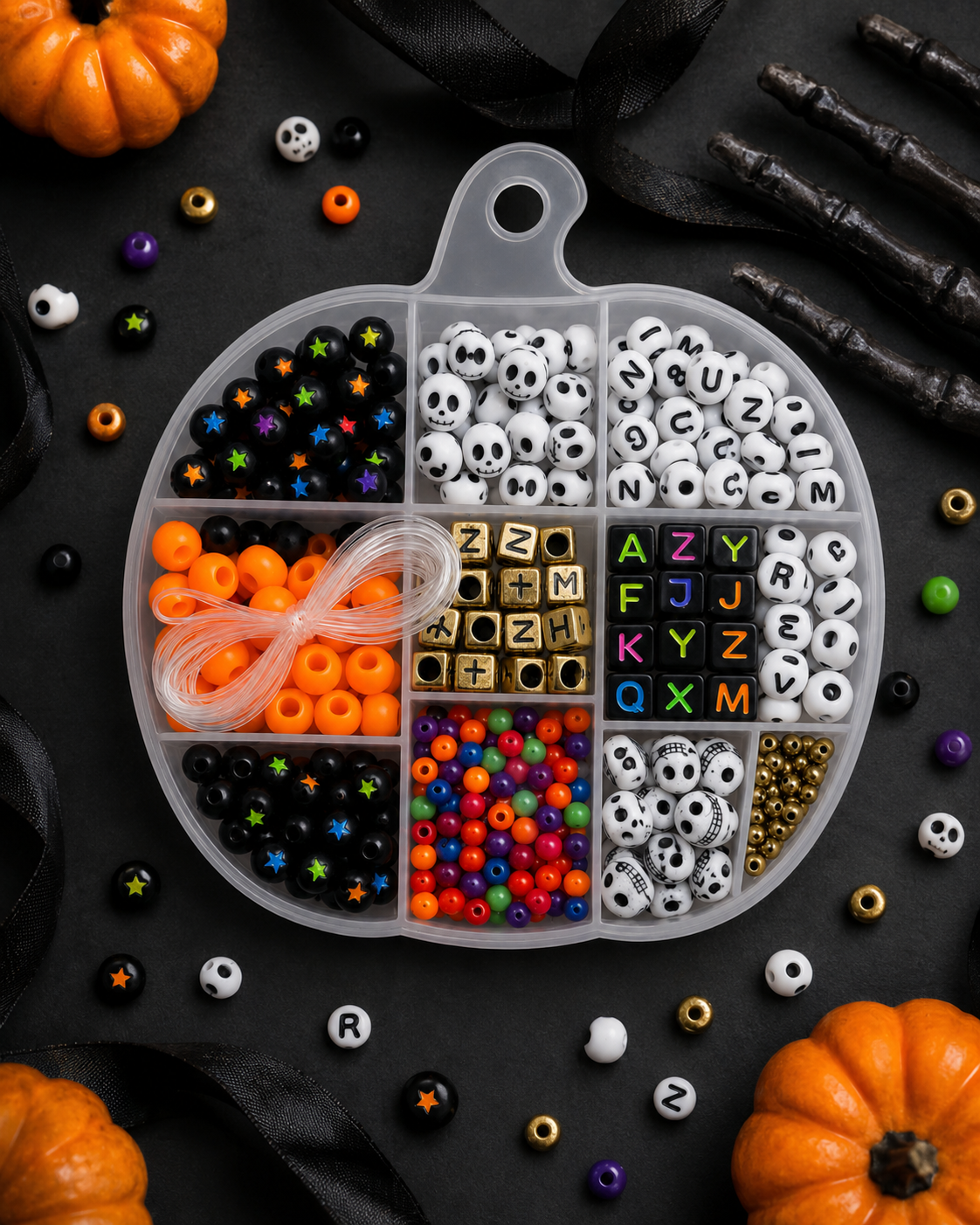 Halloween bracelet-making kit styled on a black background with pumpkins, ribbon and spooky seasonal accents