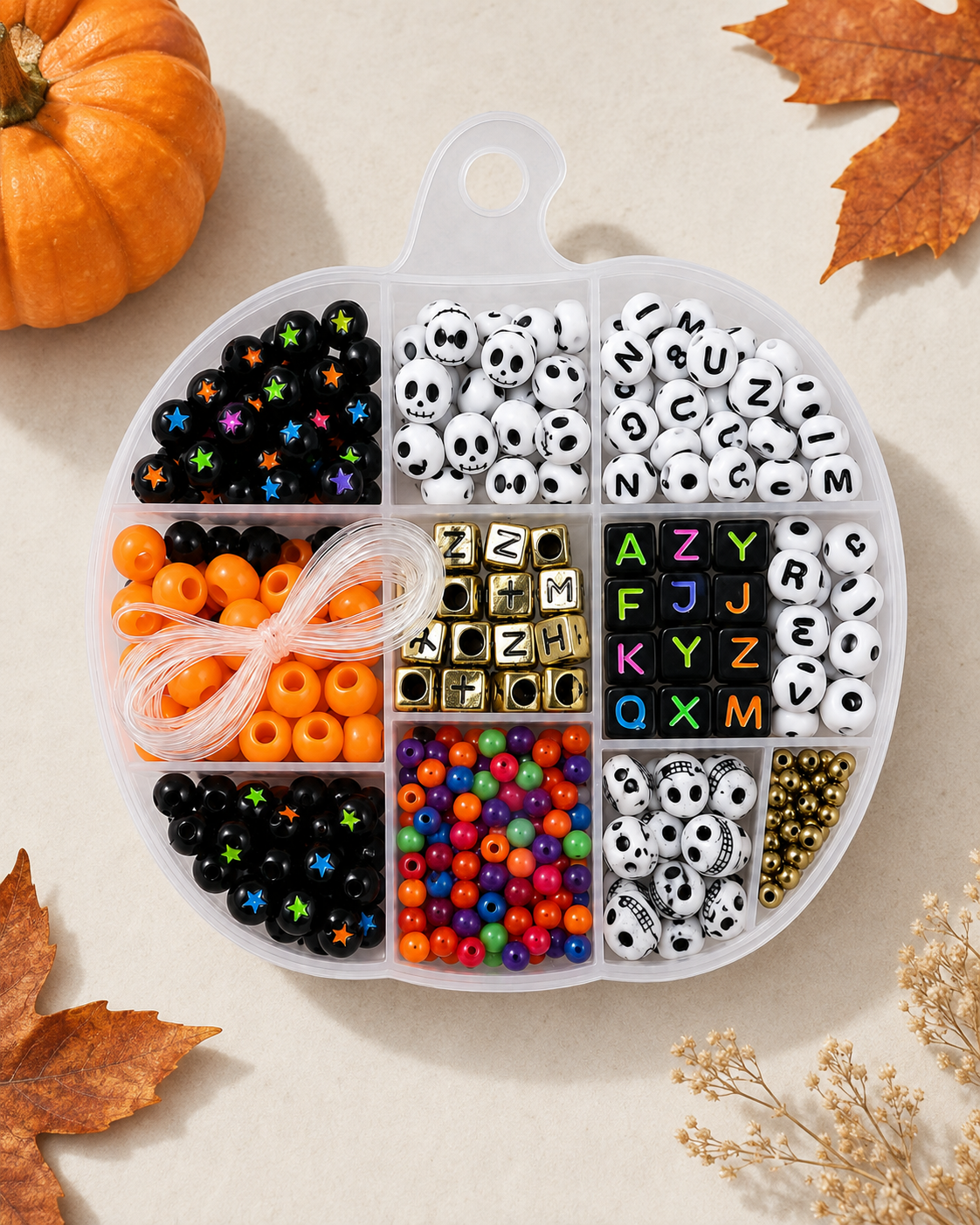Halloween bead bracelet kit styled with autumn leaves and a pumpkin, showing assorted beads and stretch cord