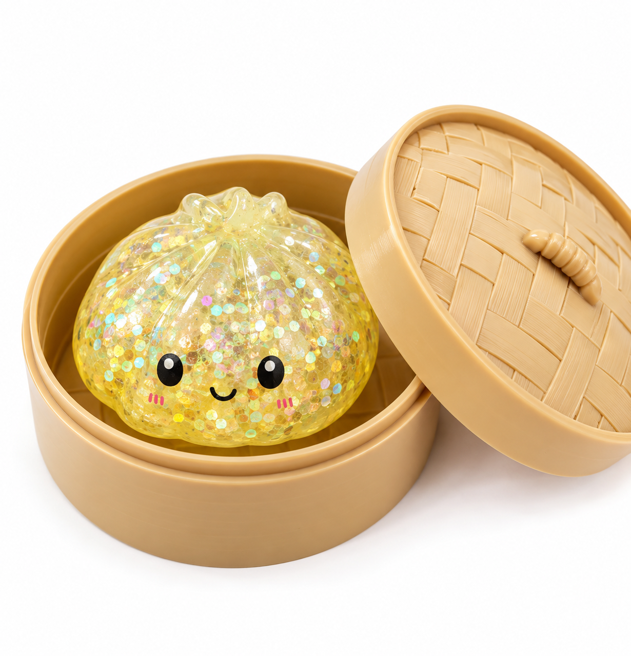 A cute, round, pumpkin-shaped glittery squishy toy with a smiling face, presented inside a beige round container with a woven-texture lid on a white background.