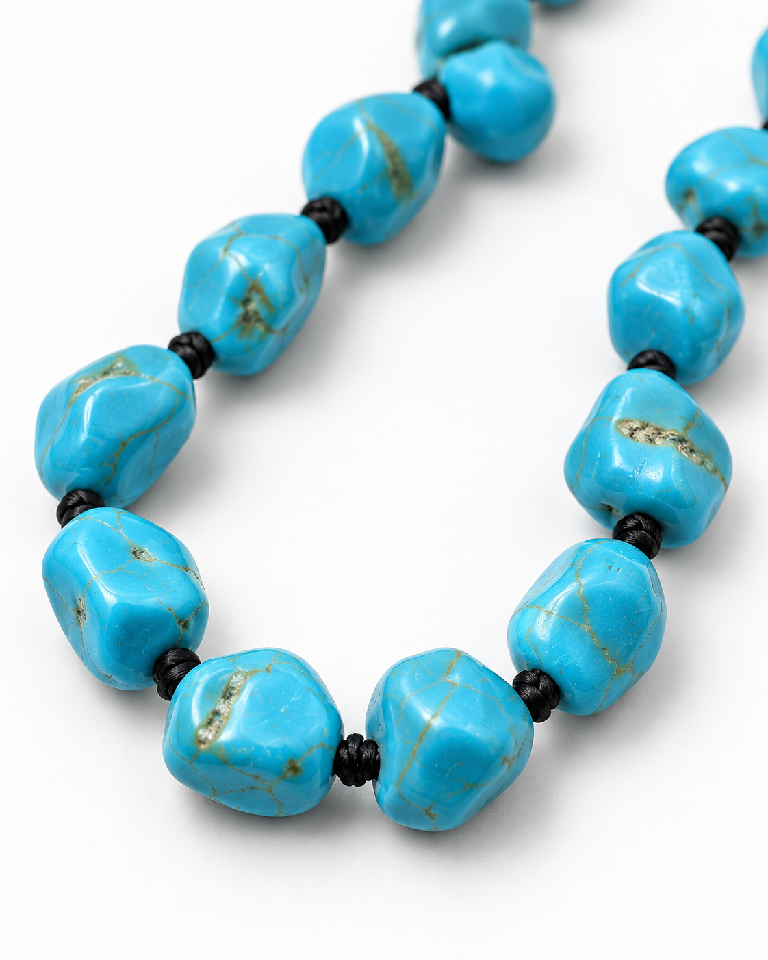 A close-up of a chunky turquoise bead necklace on a clean white background. The beads are a vibrant turquoise blue with natural matrix veining and are separated by small black spacer beads.