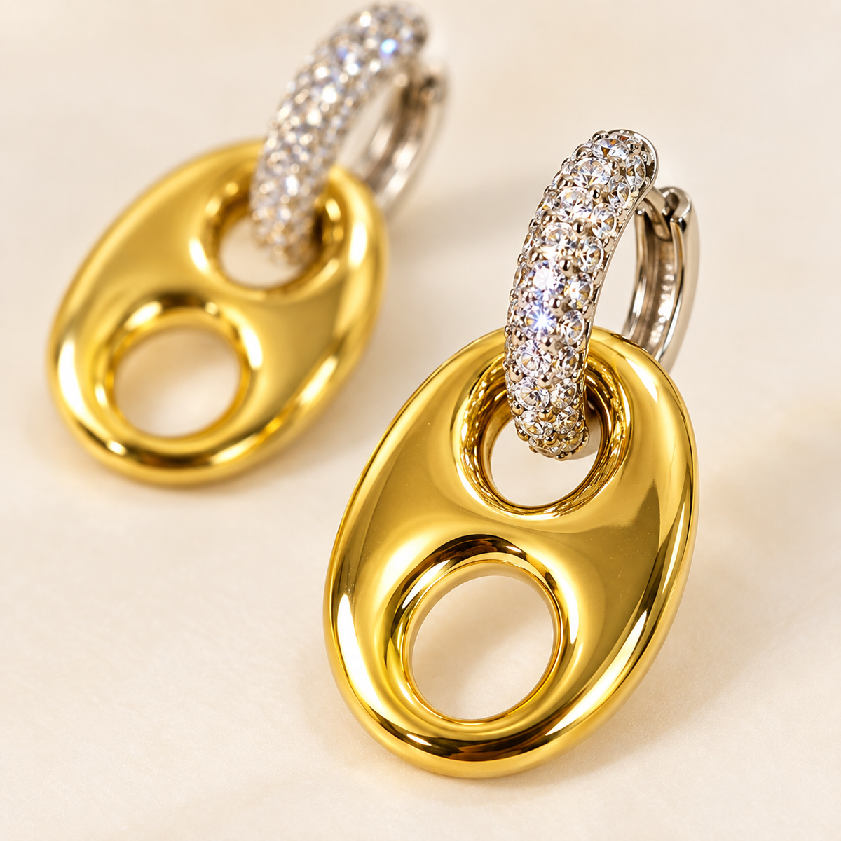 Close-up of gold horse bit drops and crystal silver-tone huggie hoops