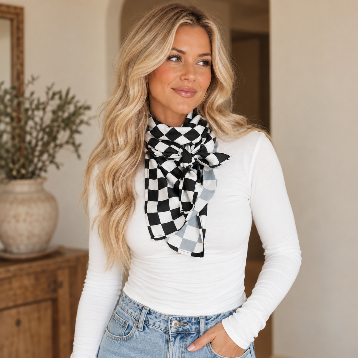 Blonde woman wearing a checkerboard wild rag with a fitted white tee and light wash denim
