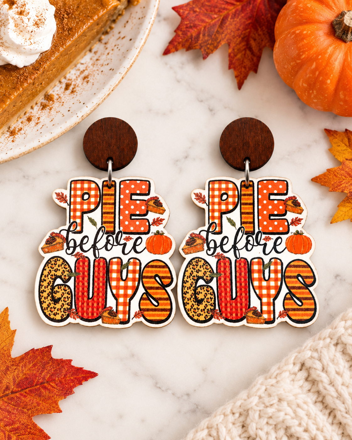 Pie Before Guys wooden earrings styled with pumpkin pie, autumn leaves, and seasonal decor
