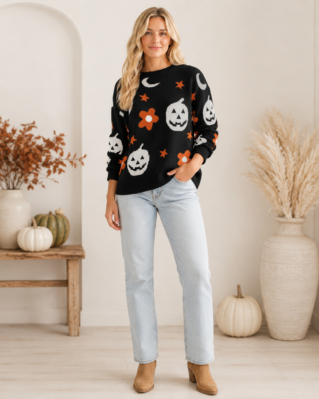 Emma wearing the Moonlit Mischief black Halloween knit sweater with light-wash jeans and western ankle boots.