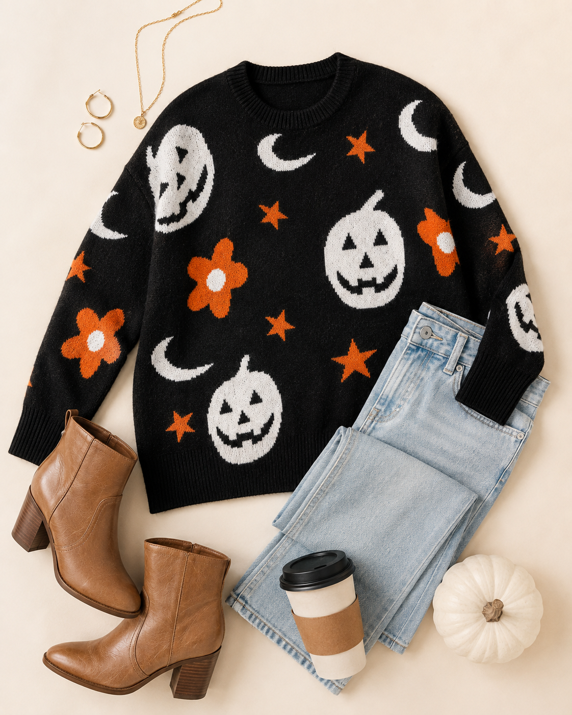 Flat lay of the Moonlit Mischief black Halloween sweater styled with light-wash denim, western boots, gold jewelry and a white pumpkin.