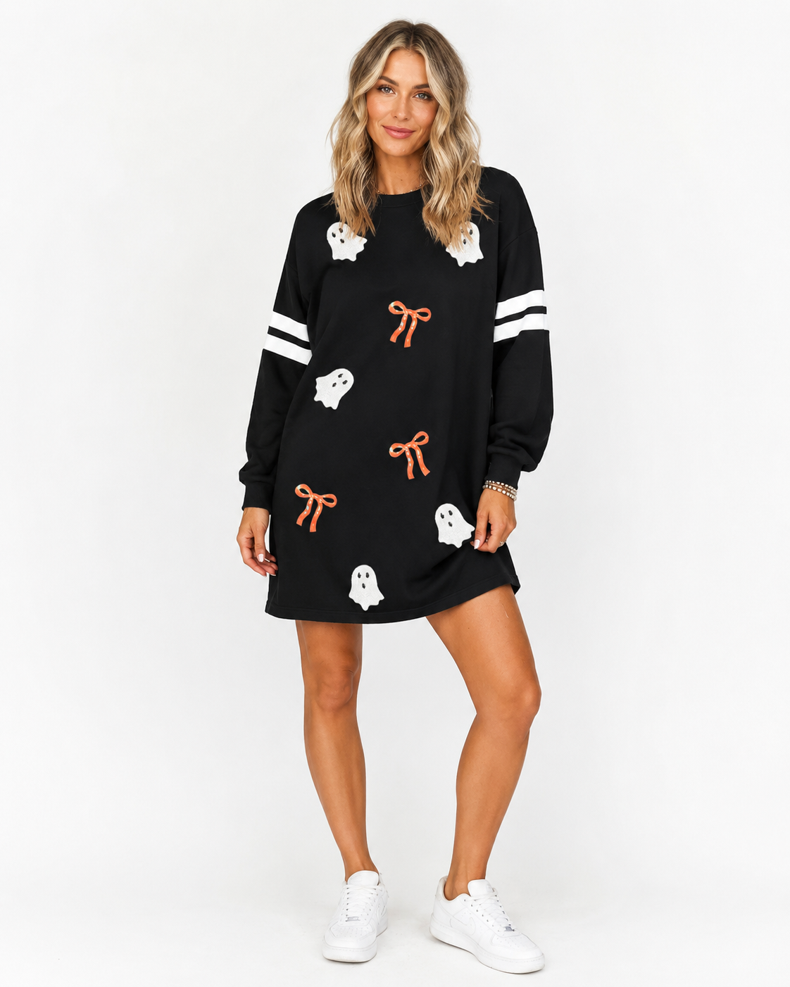 Black Ghost & Bow Varsity Sweatshirt Dress with white ghost graphics, orange bow accents, and striped sleeves on a white background.