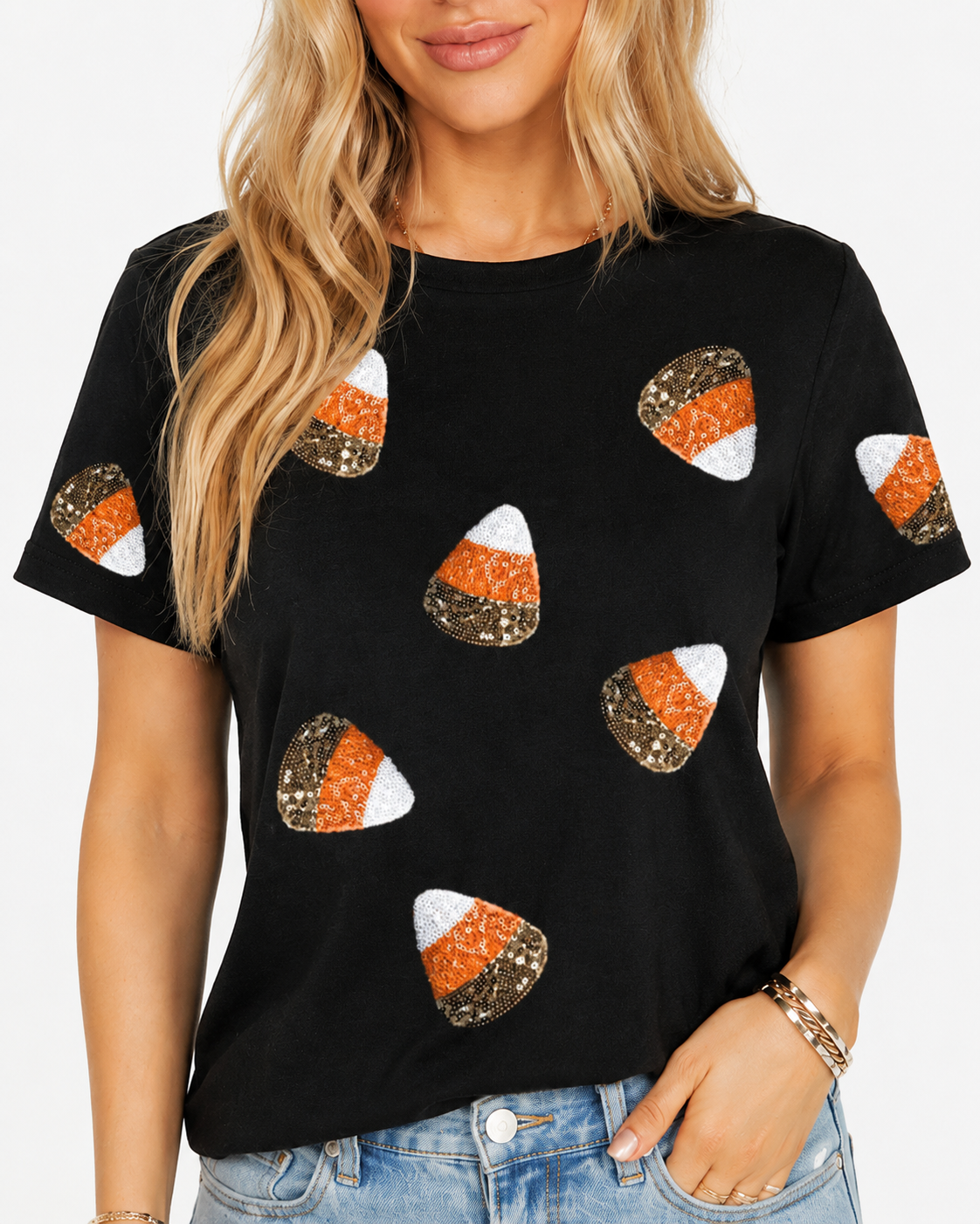 Close-up of the black Halloween tee showing sparkling orange, white, and metallic sequin candy corn patches.