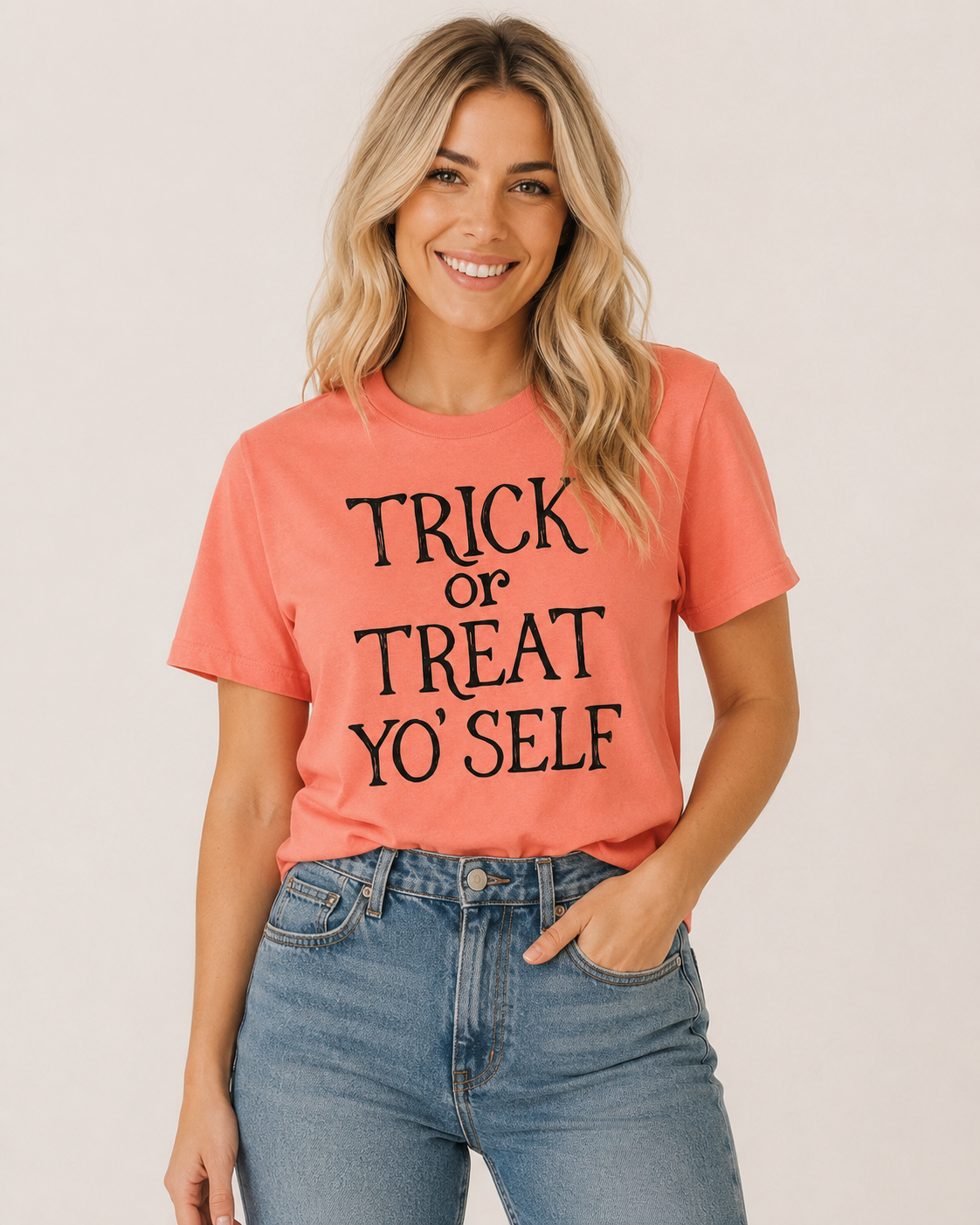 Trick or Treat Yo’Self coral Halloween graphic tee with black lettering on bleach blonde model Emma