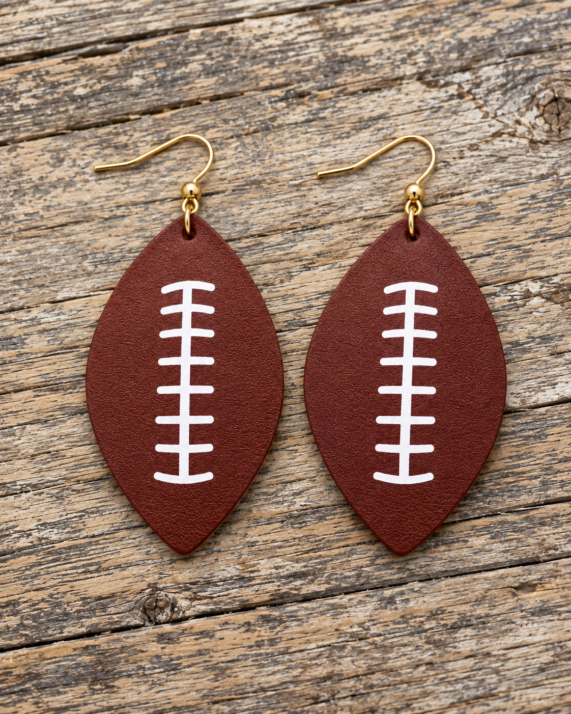 Football earrings displayed on a neutral jewelry stand with warm fall and game-day styling