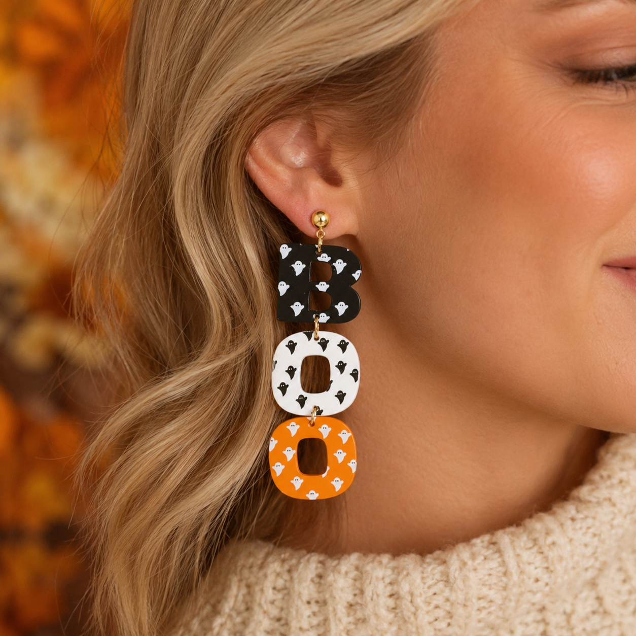 Close-up of BOO Halloween statement earring with ghost print letters and gold-tone stud