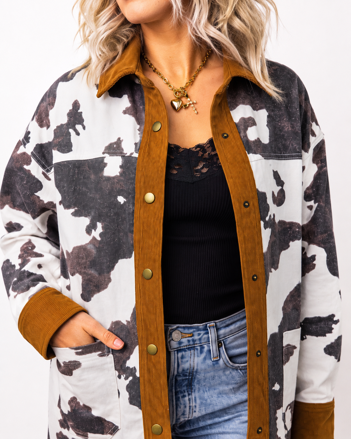 Close-up of the Multicolour Western Cow Print Denim Jacket showing the brown corduroy collar and trim, snap buttons, cow print pattern and front pocket detail.