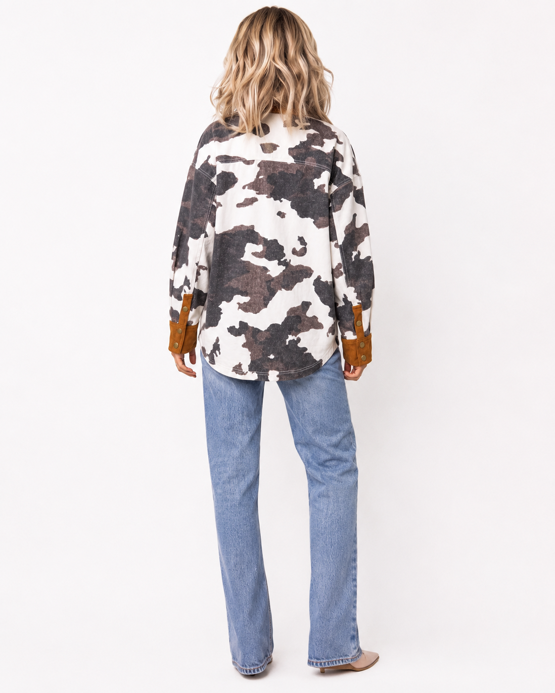 Back view of Emma wearing the Multicolour Western Cow Print Denim Jacket with light wash jeans, showing the full cow print pattern and relaxed fit.