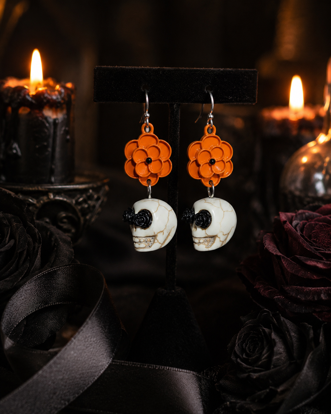 Marigold Mourning earrings displayed in a moody candlelit Halloween scene with black roses and dark décor