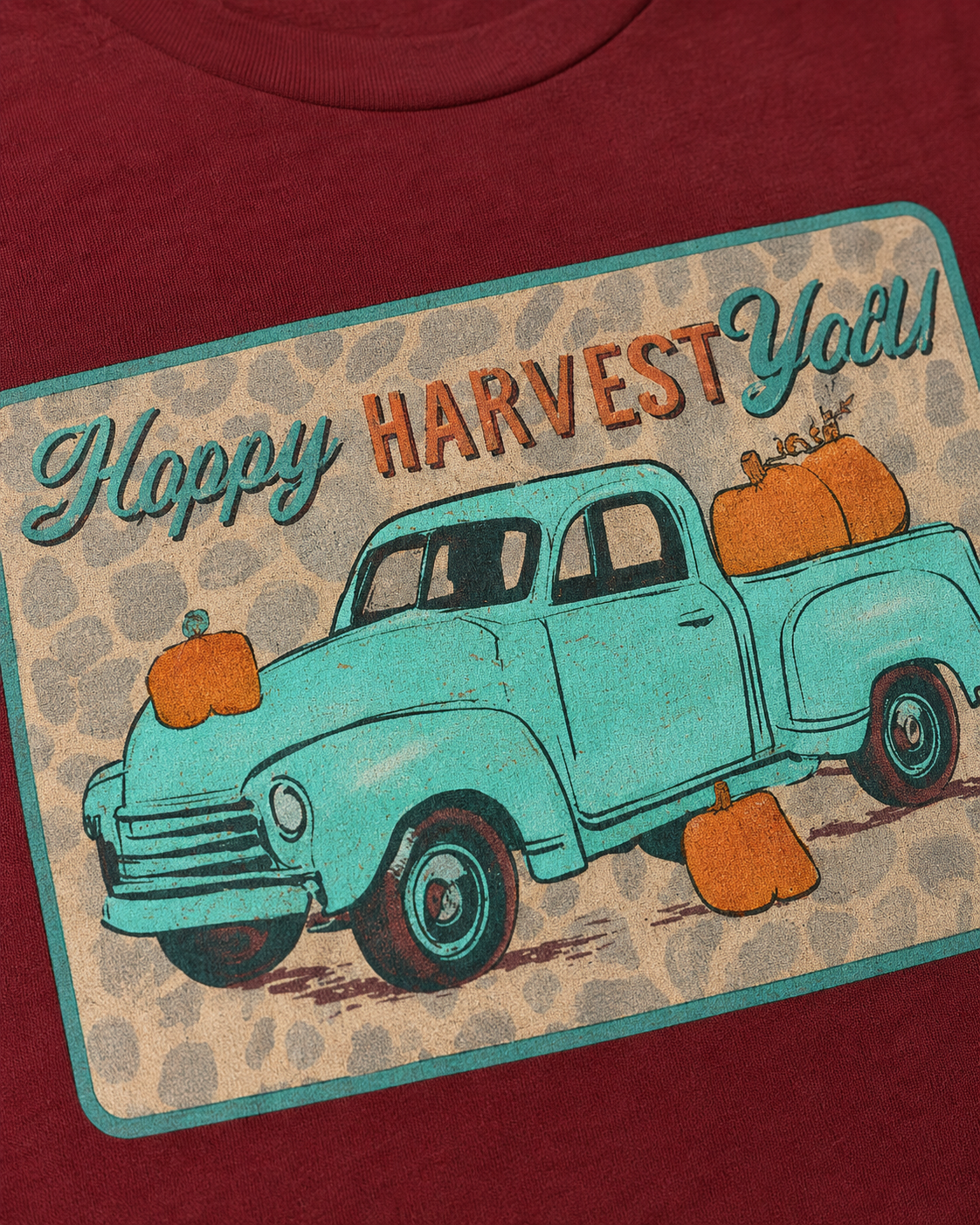 Close-up of Happy Harvest Y’all graphic showing turquoise vintage truck, pumpkins and leopard-inspired background