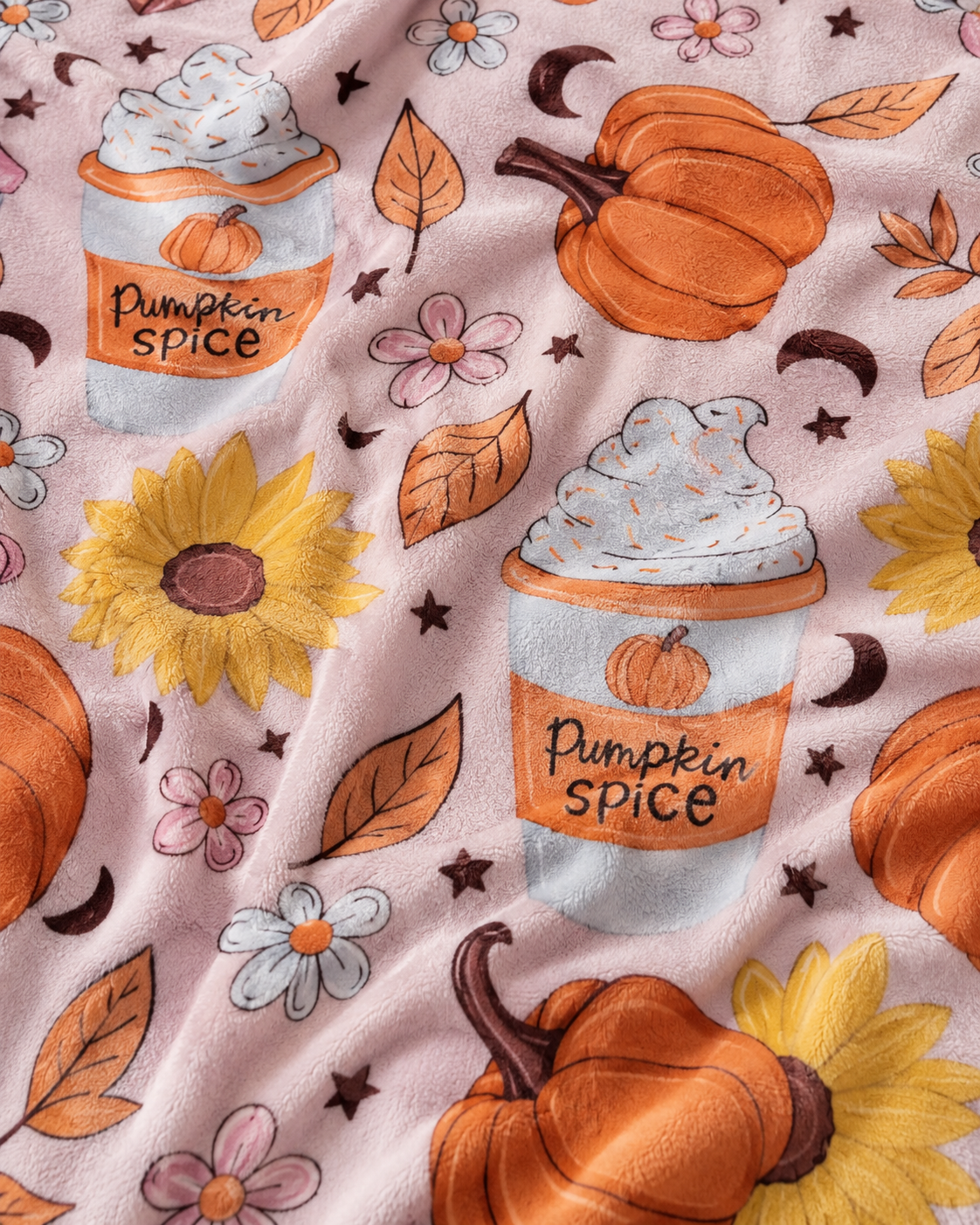 Close-up of plush fall blanket showing pumpkin spice cups, pumpkins, sunflowers, flowers, leaves, moons and stars