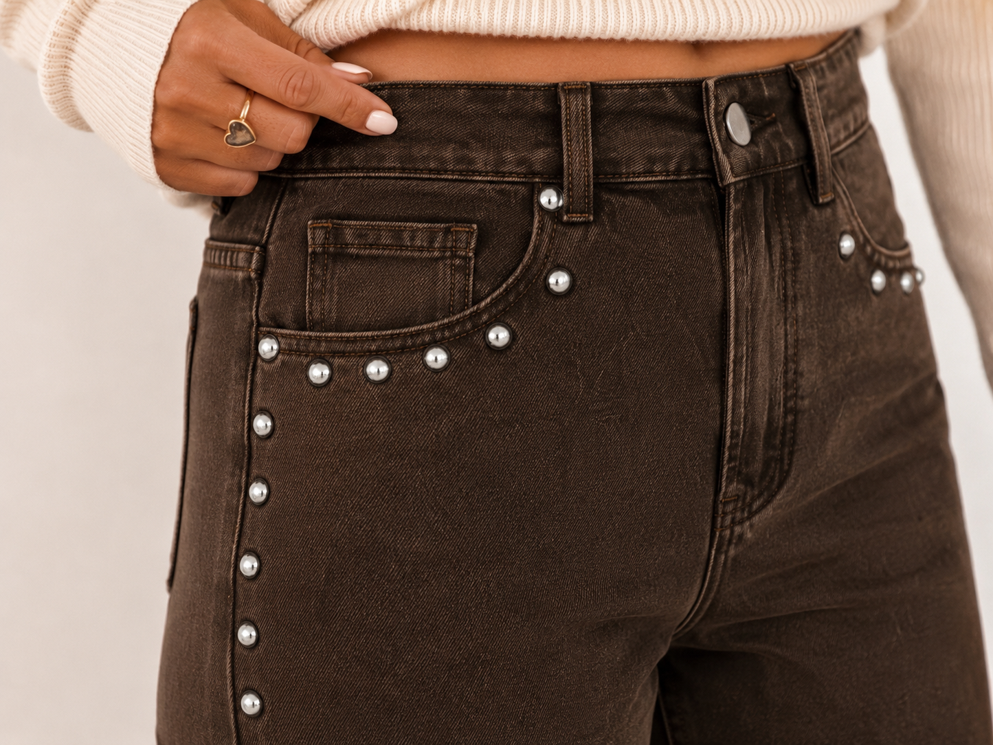 Close-up of the Saddle Stud Jeans showing the rich coffee wash, silver stud detailing, waistband, front pockets and denim texture.