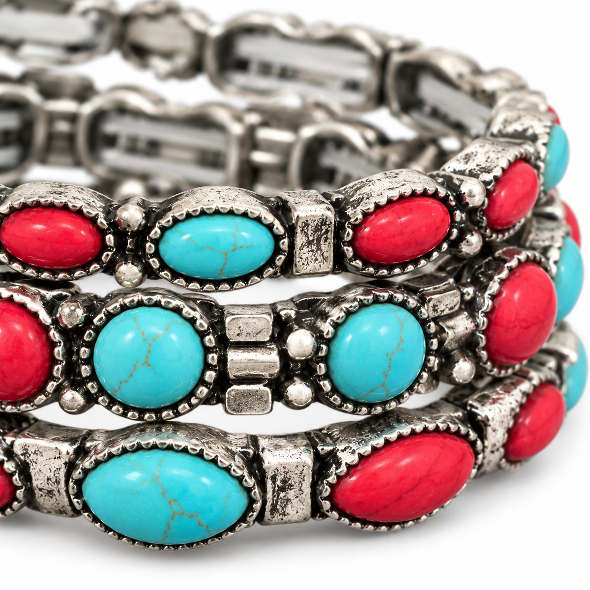 Close-up of faux turquoise-colored and red stones with antiqued silver-tone bracelet detailing
