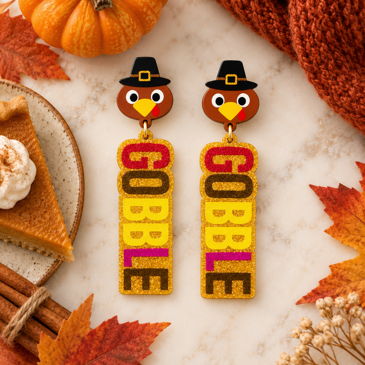 Gobble turkey acrylic earrings styled with pumpkin pie, pumpkins, cinnamon sticks, and autumn leaves