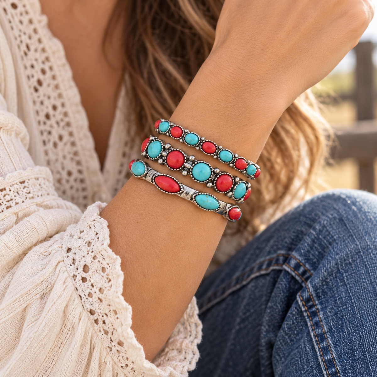 Woman wearing three-piece faux turquoise-colored and red western bracelet stack with denim