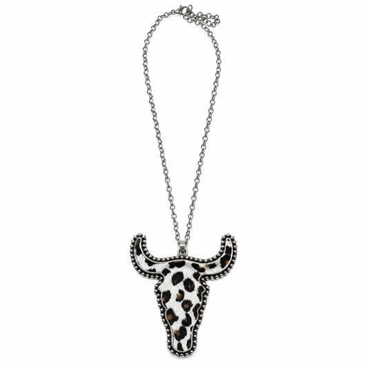 A silver-toned chain necklace featuring a bull skull pendant with a black and white leopard print pattern and silver beaded trim, shown against a plain white background.