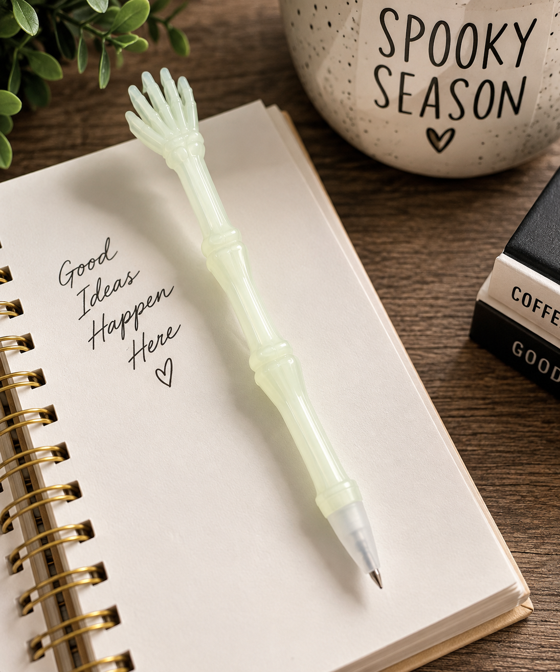 Glow-in-the-dark skeleton hand pen styled on a notebook with spooky season desk decor
