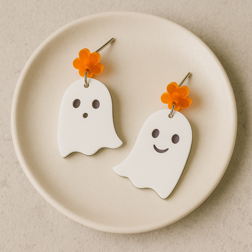 Ghost-shaped earrings with flower charms on a beige plate