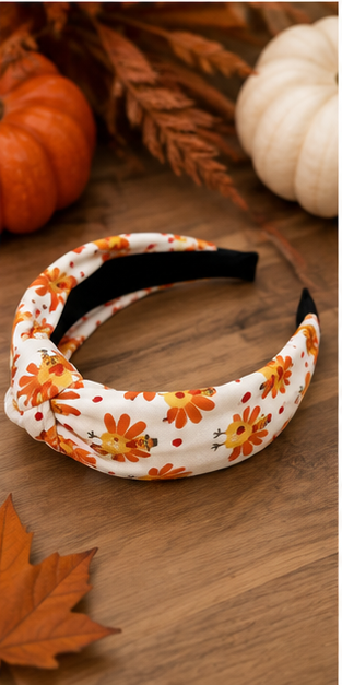 Blonde woman wearing festive turkey print headband with autumn pumpkins in the background